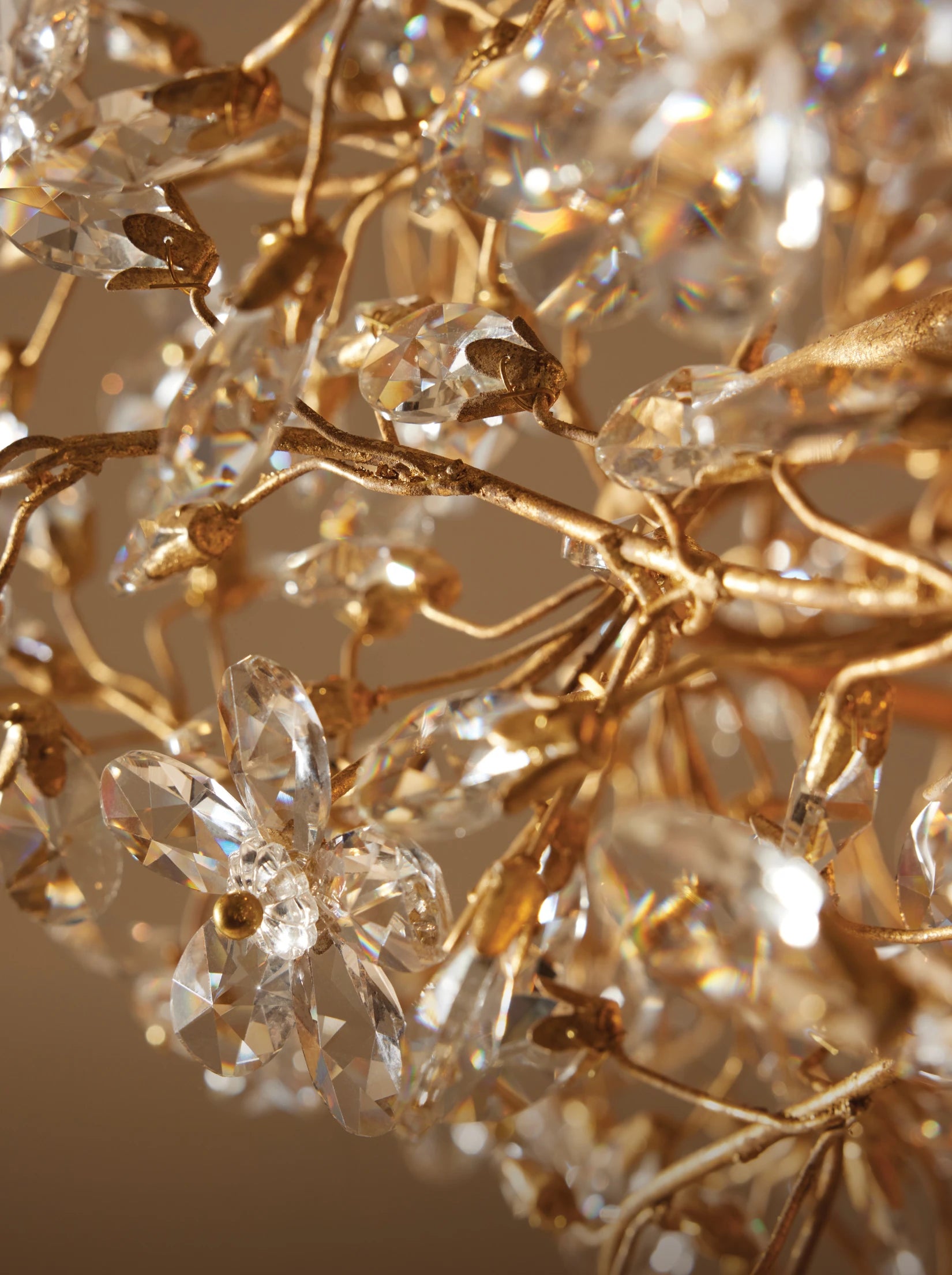 Close-up of gold chandelier branches adorned with crystal flower-shaped accents.