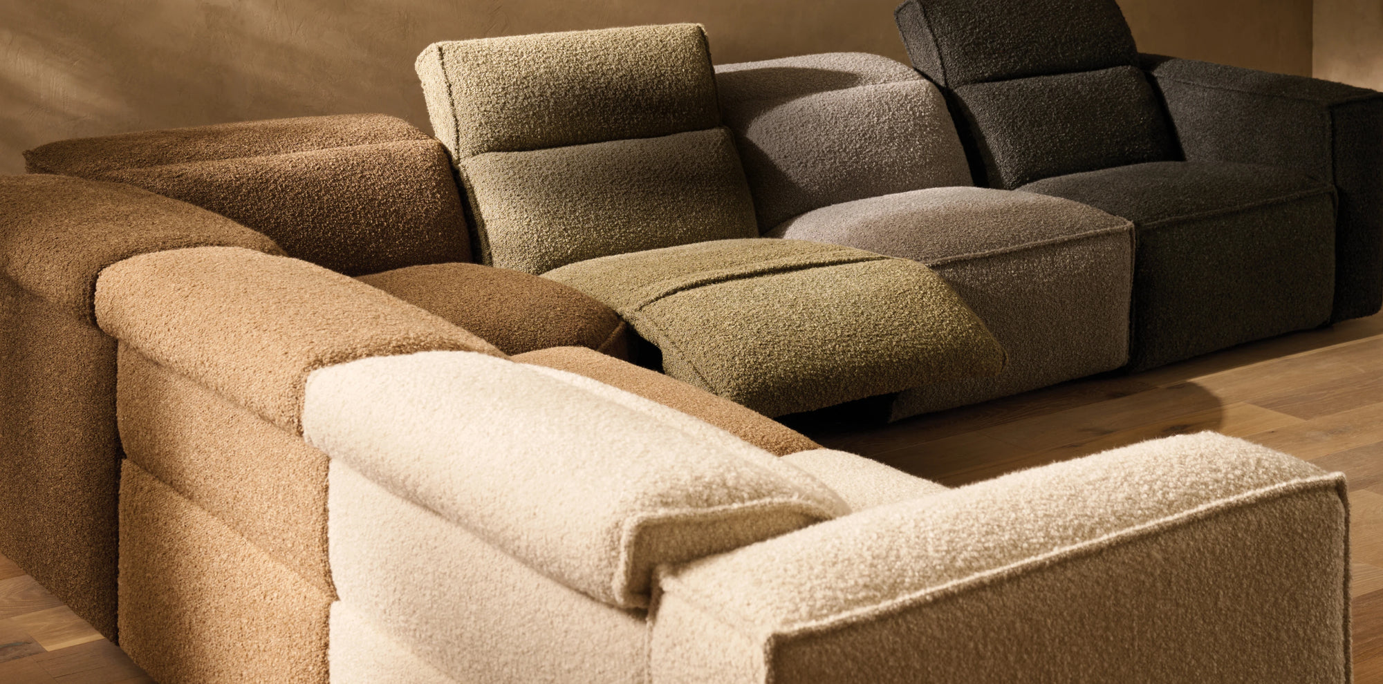 Close-up of a modular sectional sofa layered in richly textured arhaus custom upholstery, blending soft ivory, sand, moss, and charcoal tones.