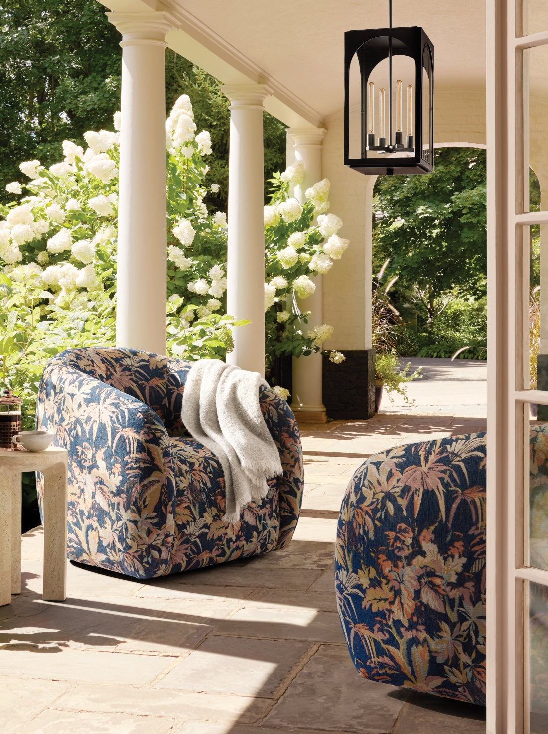 Outdoor chairs in unique, colorful, floral fabrics in a bright outdoor environment.