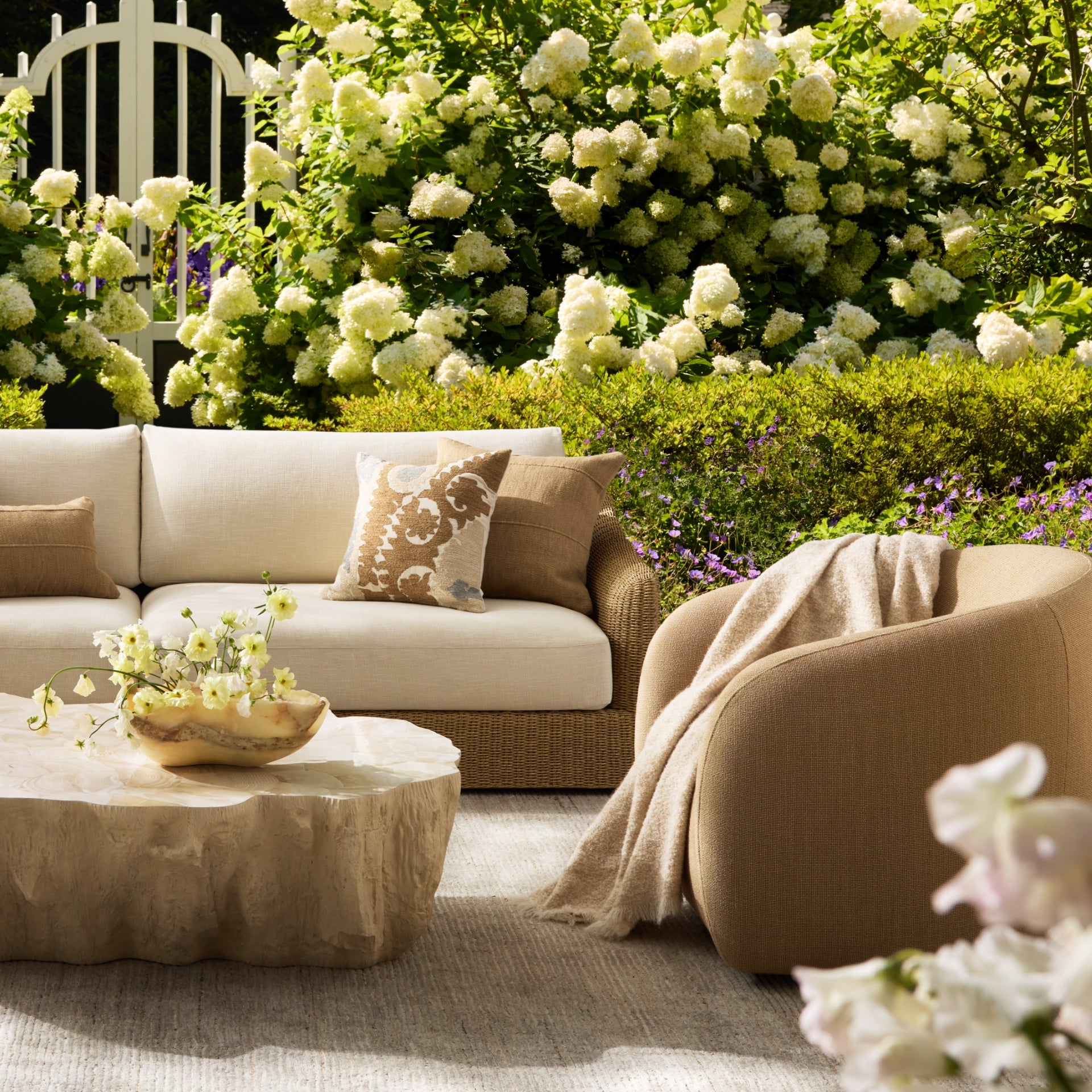 Outdoor living space with cushioned seating, natural materials, and layered textures, styled for a relaxed and elevated atmosphere.