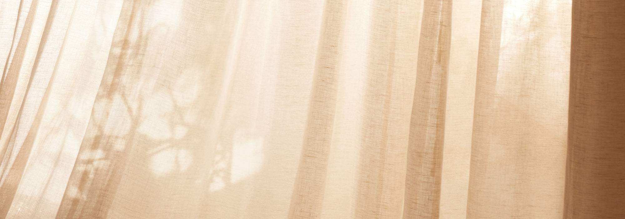 Soft sunlight illuminating sheer linen curtains, creating a warm and airy atmosphere with subtle natural shadows.